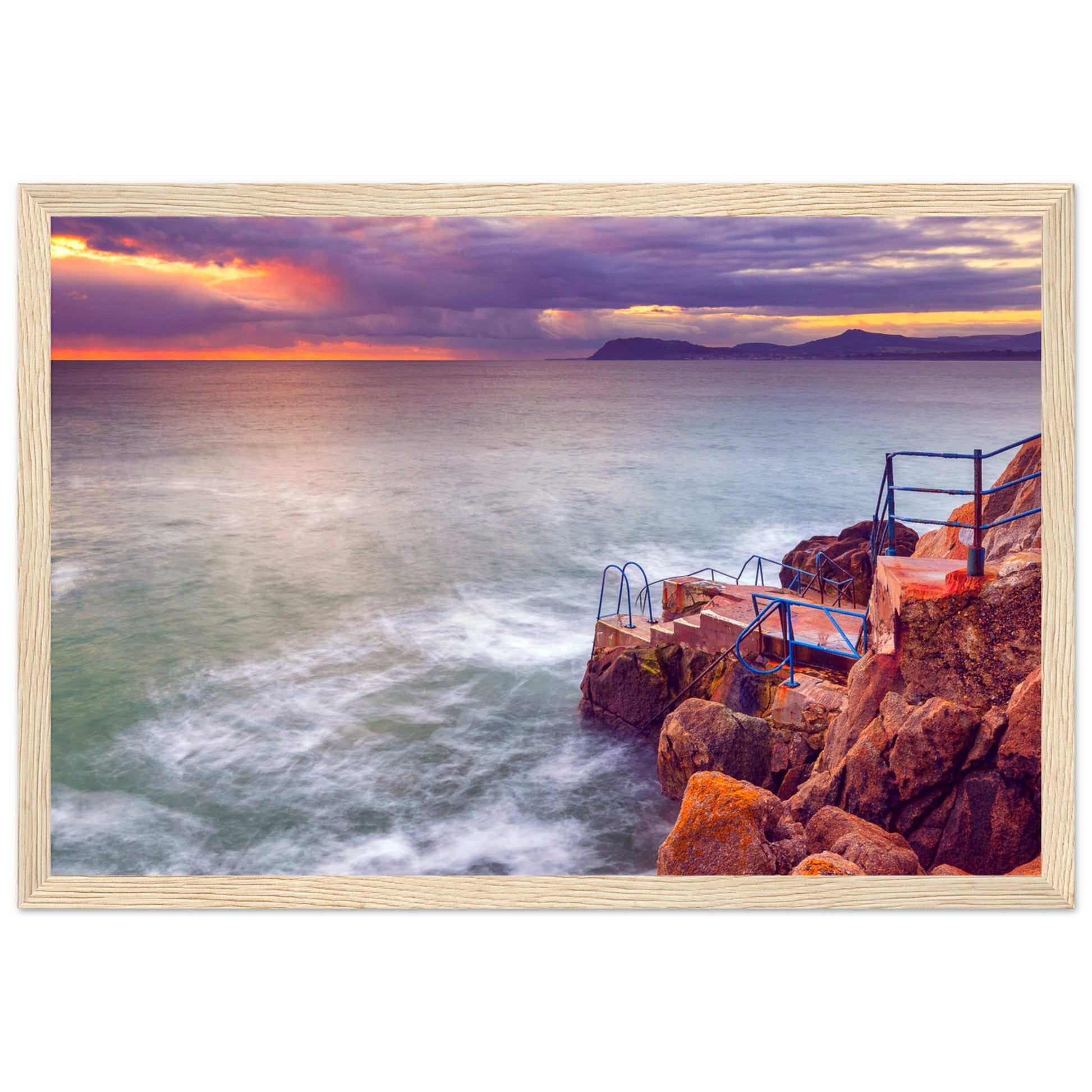 Framed wall art print of Vico Baths in Dalkey, Ireland, showcasing the scenic coastal beauty with clear waters and natural rock formations. Perfect for adding a touch of Irish charm to any room. High-quality print with vibrant colors and elegant frame.