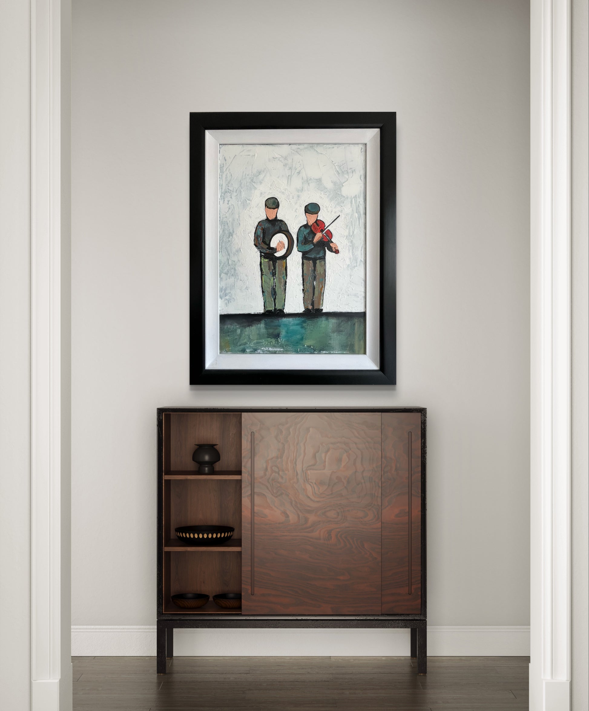 Painting titled "Traditional Irish Musicians" by Ó Maoláin, featuring two musicians: one playing a fiddle and the other a bodhrán, against a whitewashed background with grey and green tones. Framed in a black wooden frame with a white scoop inlay.