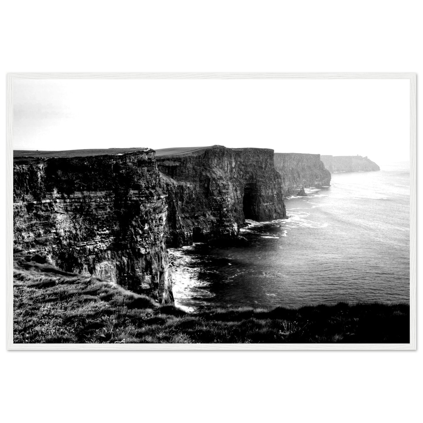 Monochrome photo of Cliffs of Moher, framed elegantly. Captures rugged beauty, contrasts. Minimalist frame complements decor. Evokes awe.